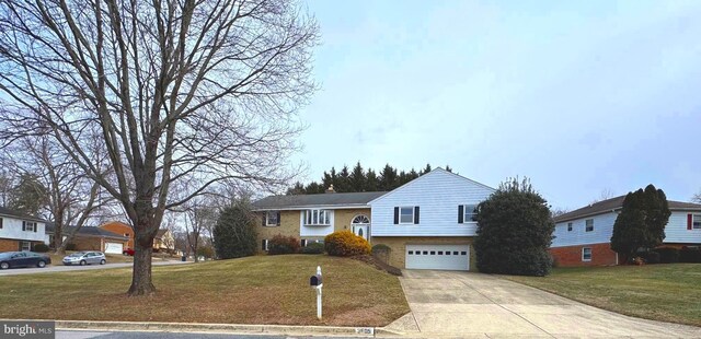 view of front of property featuring concrete driveway, an attached garage, and a front lawn