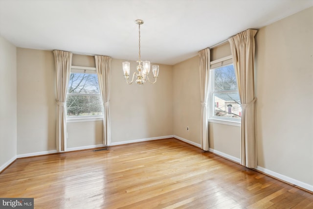 unfurnished dining area with plenty of natural light, baseboards, and wood finished floors