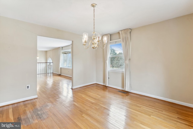 empty room featuring baseboards, wood finished floors, and a healthy amount of sunlight