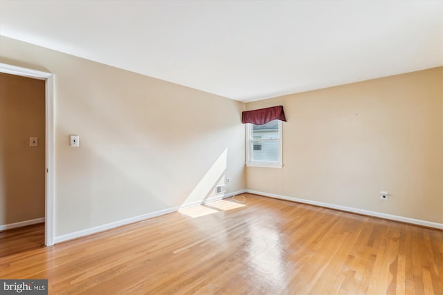 unfurnished room with light wood-style flooring and baseboards