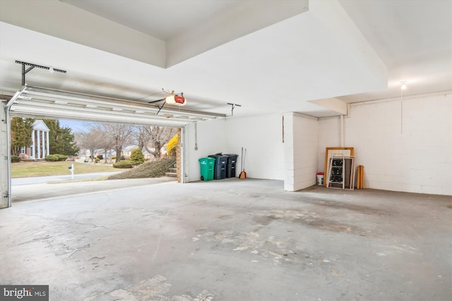 garage with concrete block wall and a garage door opener