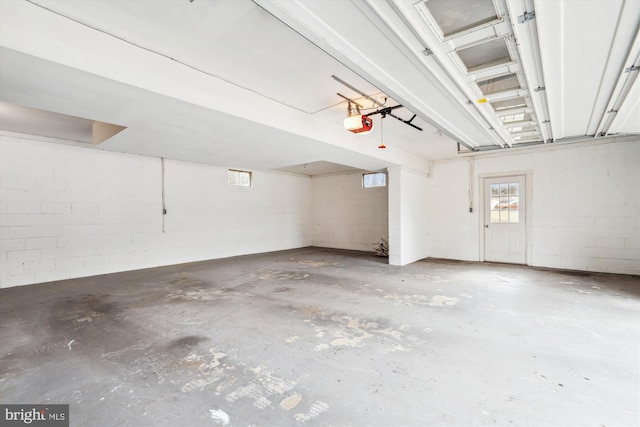 garage with a garage door opener and concrete block wall