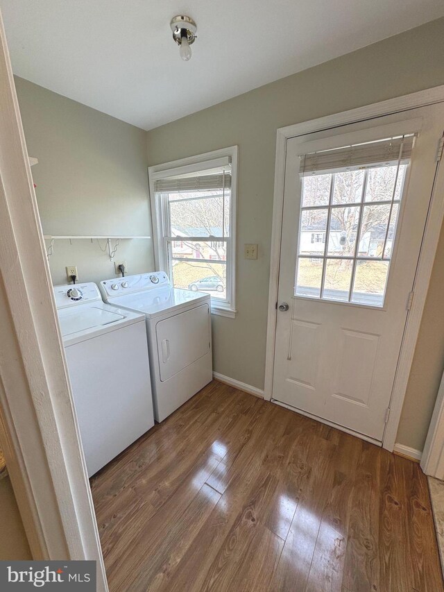 laundry area featuring laundry area, light wood-type flooring, washing machine and dryer, and baseboards