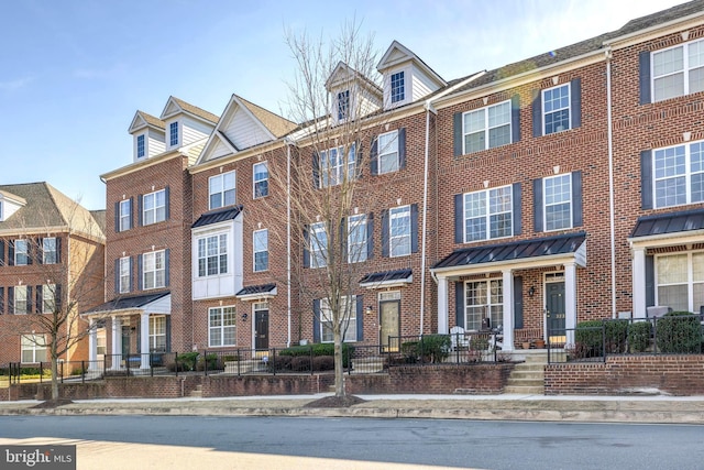 townhome / multi-family property featuring brick siding and a standing seam roof