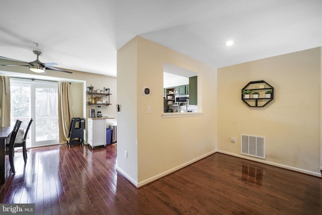 unfurnished dining area with visible vents, ceiling fan, dark wood-type flooring, and baseboards