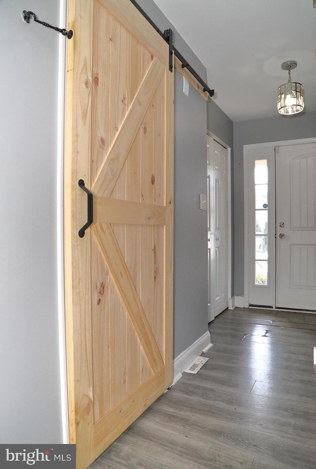 foyer entrance with wood-type flooring and a barn door