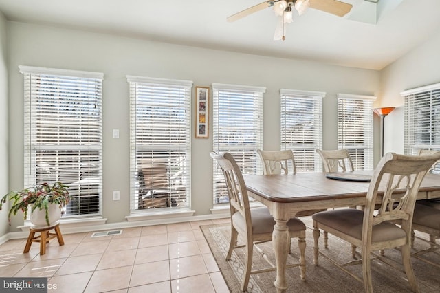 dining space with light tile patterned floors, vaulted ceiling, and ceiling fan