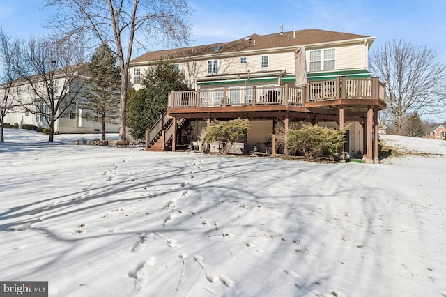 snow covered house with a wooden deck