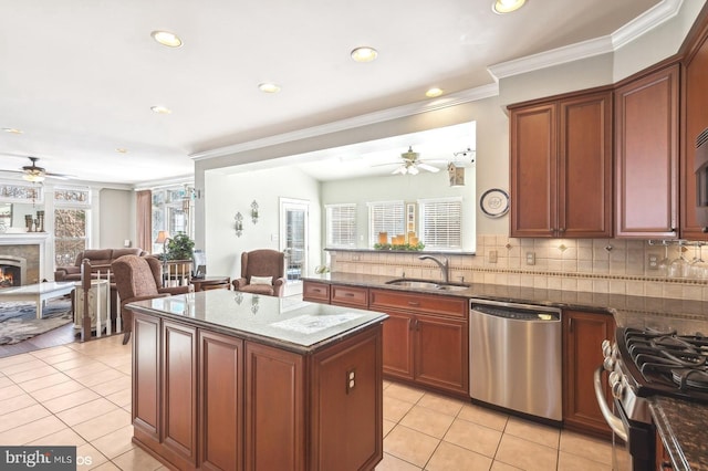 kitchen with a center island, appliances with stainless steel finishes, sink, and dark stone counters