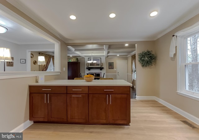 kitchen with coffered ceiling, light hardwood / wood-style flooring, ornamental molding, kitchen peninsula, and beamed ceiling