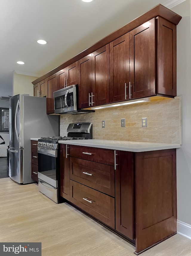 kitchen with crown molding, dark brown cabinets, stainless steel appliances, light hardwood / wood-style floors, and decorative backsplash