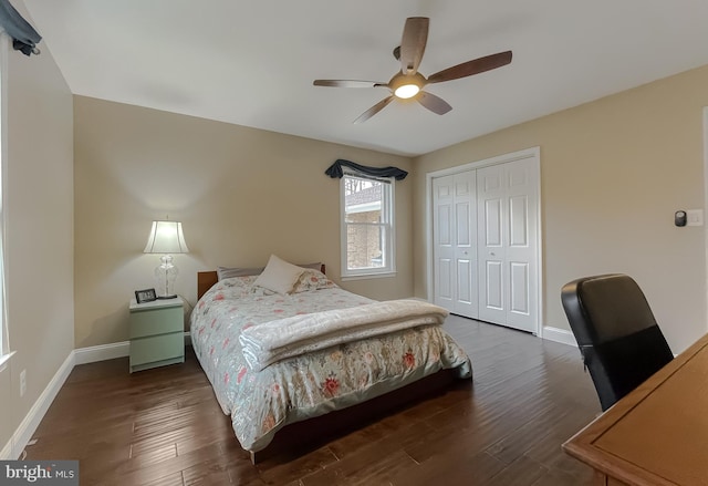 bedroom with dark wood-type flooring, ceiling fan, and a closet