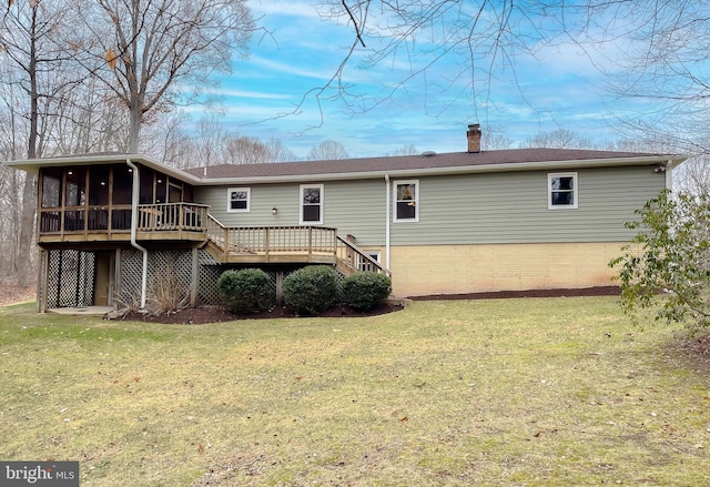 rear view of house with a lawn, a sunroom, and a deck