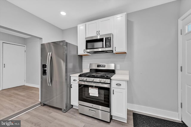 kitchen with white cabinetry, stainless steel appliances, and light hardwood / wood-style flooring