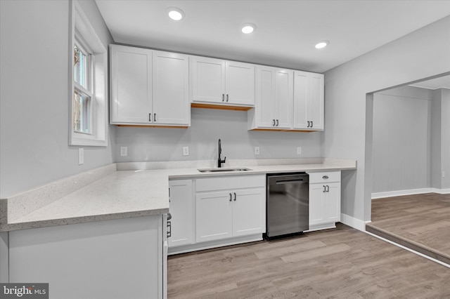 kitchen with dishwasher, sink, light hardwood / wood-style flooring, and white cabinets