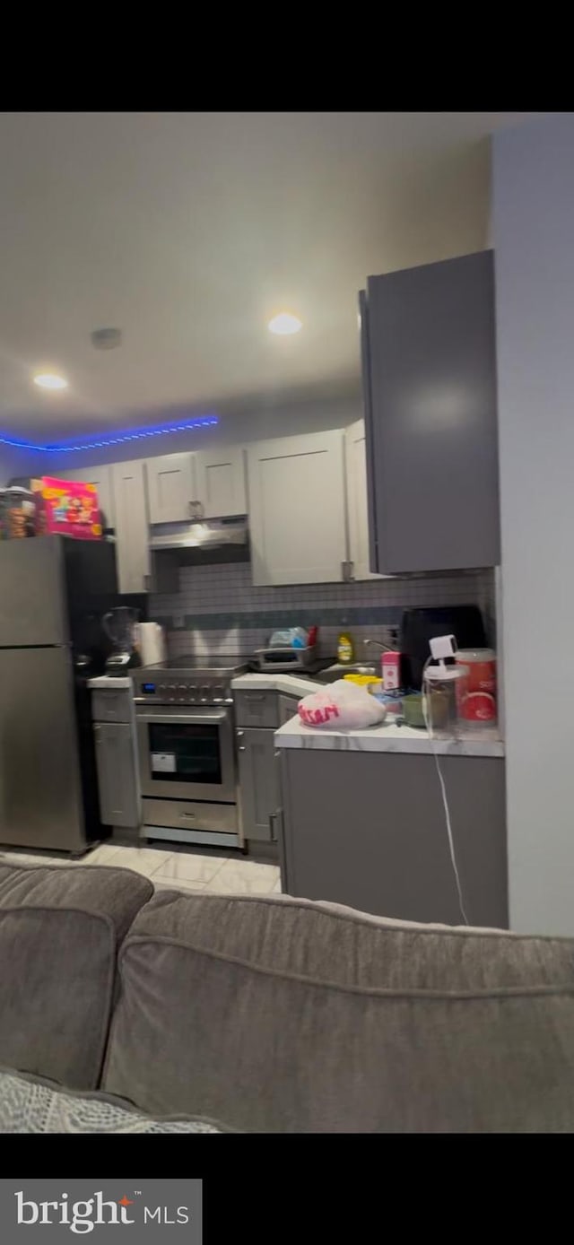 kitchen featuring backsplash, appliances with stainless steel finishes, and white cabinets