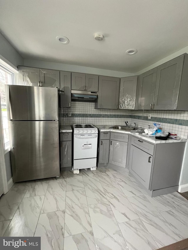 kitchen featuring sink, decorative backsplash, stainless steel fridge, and white electric stove