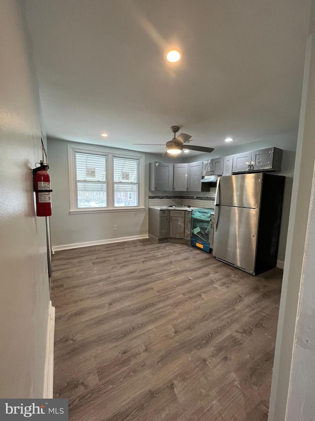 kitchen with electric stove, stainless steel fridge, ceiling fan, gray cabinetry, and dark hardwood / wood-style floors