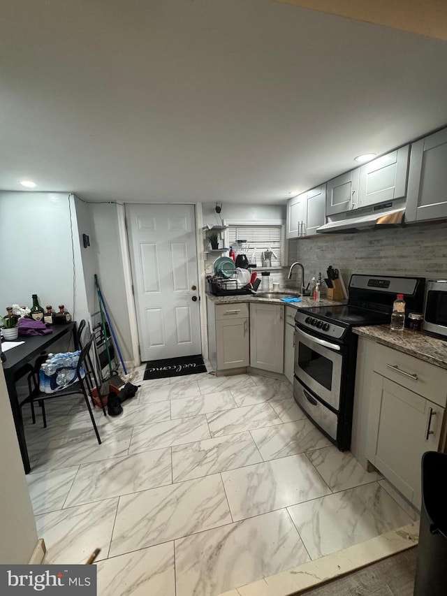 kitchen featuring sink, gray cabinetry, tasteful backsplash, appliances with stainless steel finishes, and dark stone counters