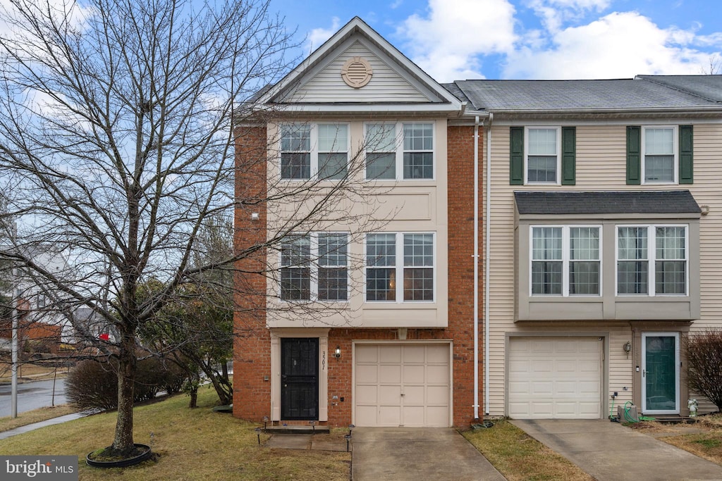 townhome / multi-family property featuring a garage and a front lawn