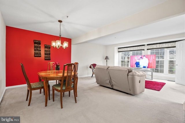 dining room featuring beam ceiling, light colored carpet, and a chandelier