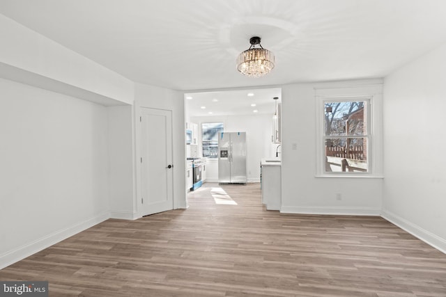 interior space featuring an inviting chandelier, sink, and light hardwood / wood-style floors