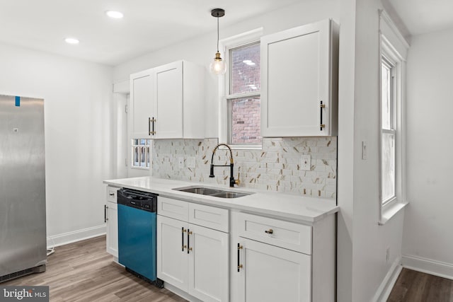 kitchen with dishwashing machine, stainless steel fridge, and white cabinets