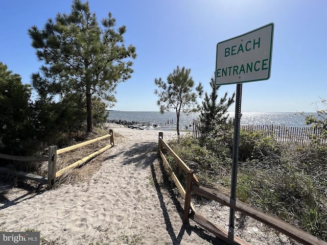 view of community with a water view and a beach view