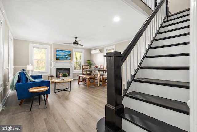 staircase featuring crown molding, ceiling fan, wood-type flooring, and a wall mounted AC