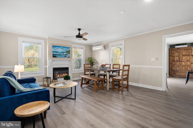 living room featuring hardwood / wood-style floors, crown molding, a wall unit AC, and ceiling fan