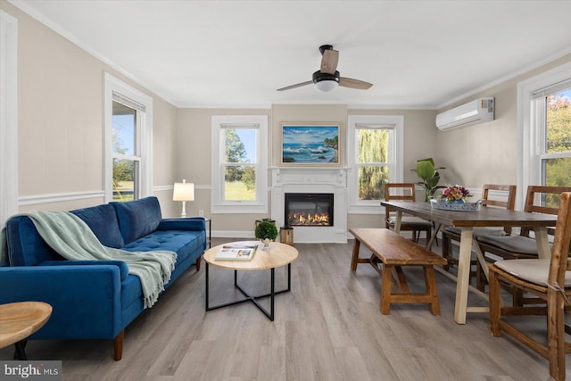 living room with plenty of natural light, a wall mounted AC, and light wood-type flooring