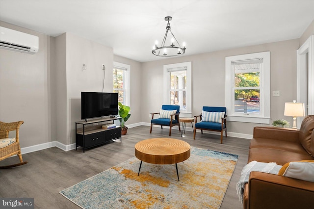 living room featuring an inviting chandelier, a wall mounted AC, and hardwood / wood-style floors