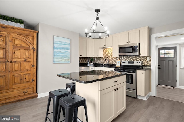 kitchen featuring a kitchen island, dark hardwood / wood-style floors, white cabinets, hanging light fixtures, and stainless steel appliances