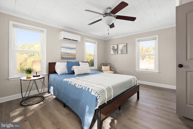 bedroom featuring multiple windows, hardwood / wood-style floors, and a wall unit AC