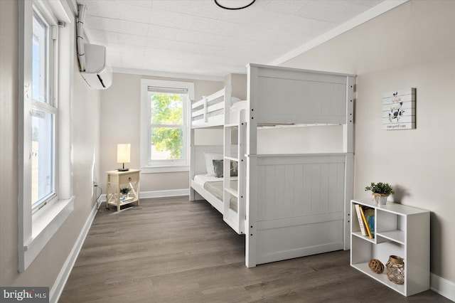 bedroom with dark hardwood / wood-style floors and a wall mounted AC