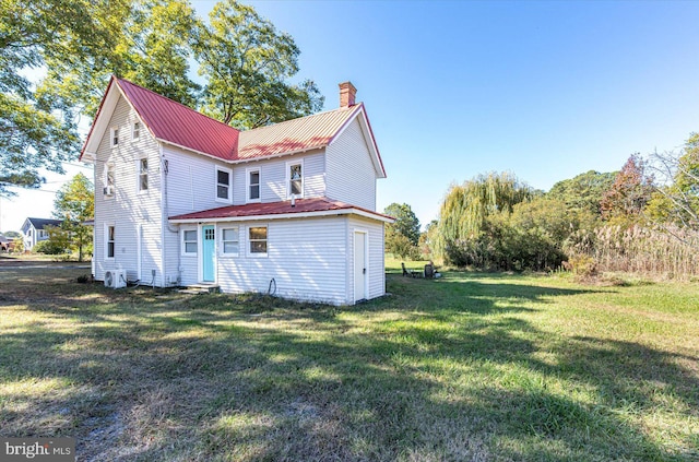 back of property featuring a yard