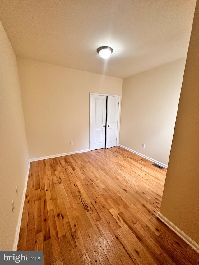 unfurnished bedroom featuring a closet and light wood-type flooring