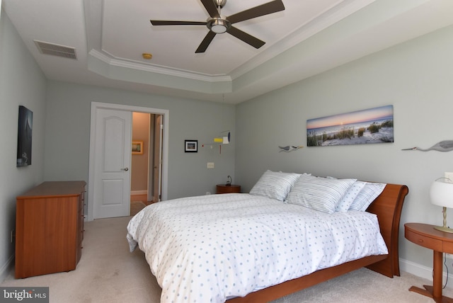 carpeted bedroom featuring crown molding, a raised ceiling, and ceiling fan