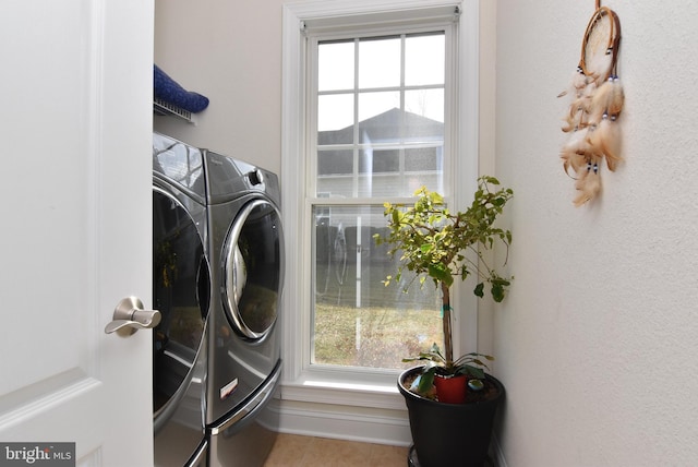 clothes washing area with plenty of natural light and washer and clothes dryer