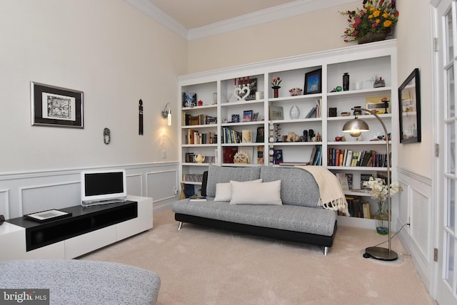 sitting room with ornamental molding and light carpet