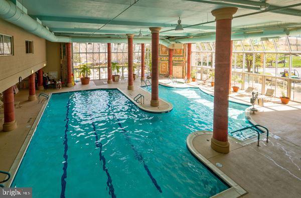 view of swimming pool featuring a patio and a lanai