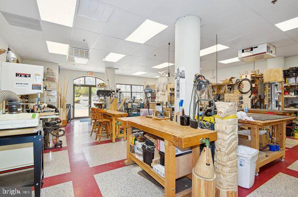 miscellaneous room with a paneled ceiling and a workshop area