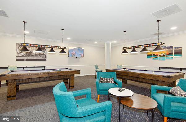 game room with dark colored carpet, ornamental molding, and pool table