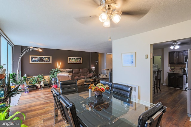 dining space with dark wood-type flooring, ceiling fan, floor to ceiling windows, and a textured ceiling