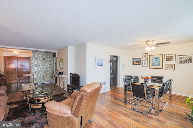 living room with ceiling fan and light hardwood / wood-style floors