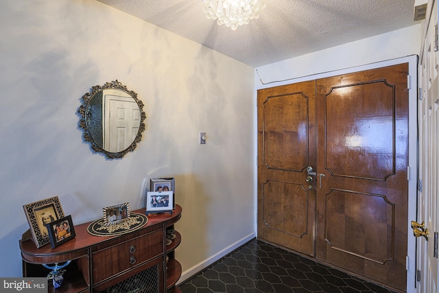 foyer with an inviting chandelier and a textured ceiling