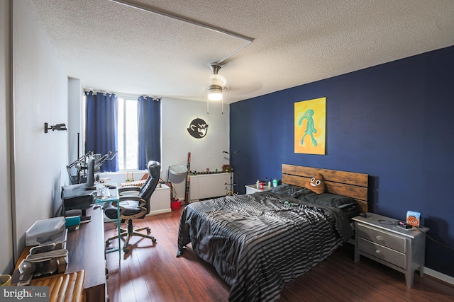 bedroom featuring ceiling fan, dark hardwood / wood-style floors, and a textured ceiling