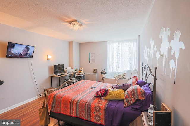 bedroom with hardwood / wood-style floors and a textured ceiling