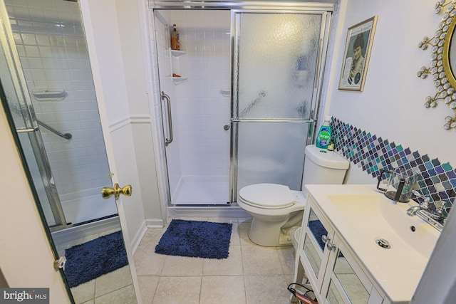 bathroom featuring tile patterned flooring, vanity, toilet, and walk in shower