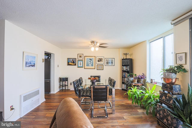 dining room featuring ceiling fan, dark hardwood / wood-style flooring, radiator, and a textured ceiling